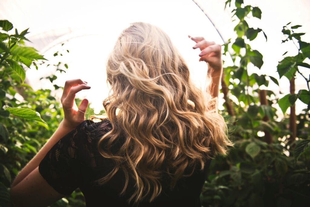 Eine Frau mit Haarverdichtung trägt ihre Haare offen in der Natur